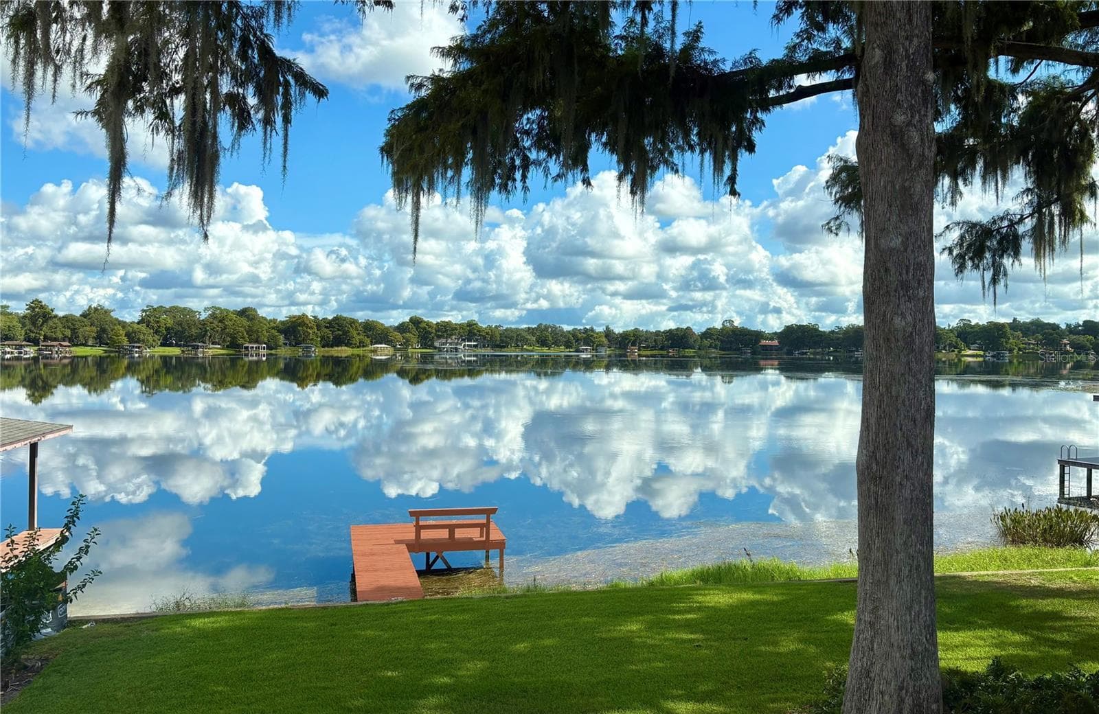 LAKE SUE framed by graceful trees and breathtaking reflections across the tranquil waters of Lake Sue, this extraordinary waterfront setting captures the timeless beauty of Central Florida lakefront living. — 2655 Lake Shore Drive, Orlando, Florida